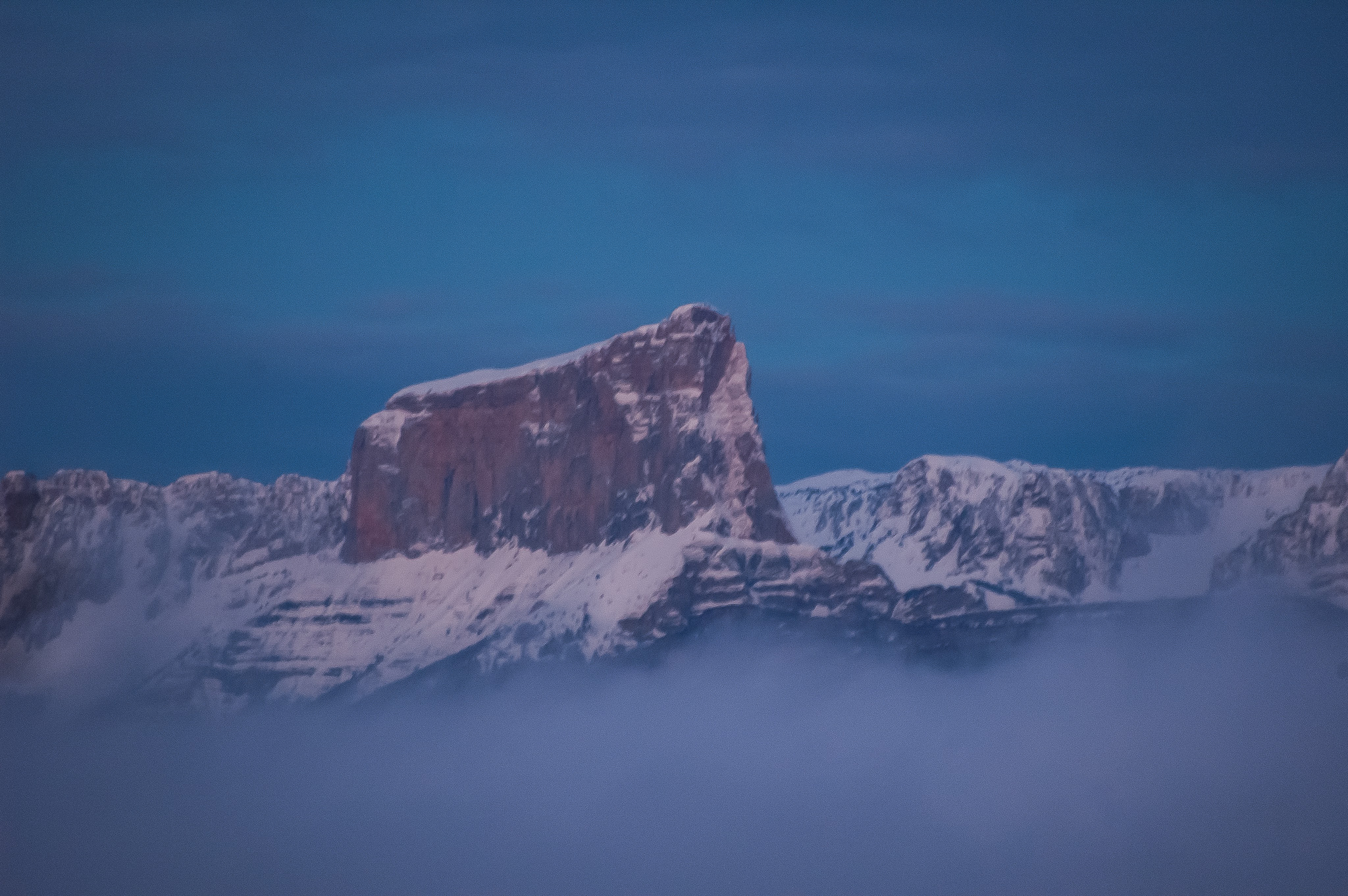 Le Mont Aiguille enneigé immergeant de la mer de nuages